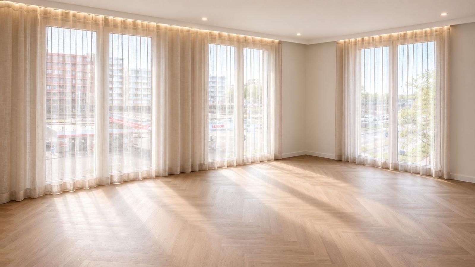 Lege woonkamer met strak gestucte wanden en visgraatvloer
