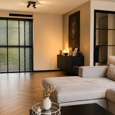 Moderne woonkamer met strak gestucte wanden en visgraatvloer